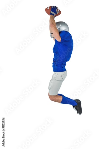 American football player catching ball in mid-air