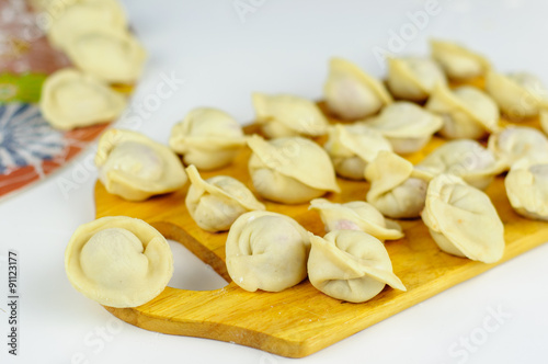 Raw dumplings with meat on table