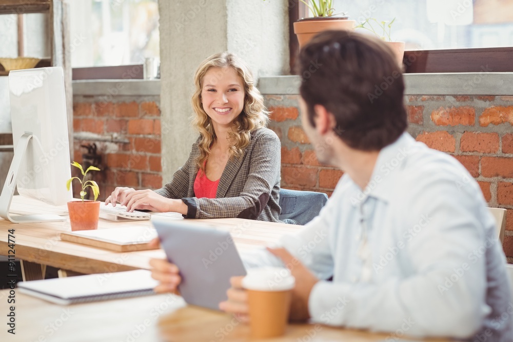 Business people discussing while working in office Business people discussing while working in office