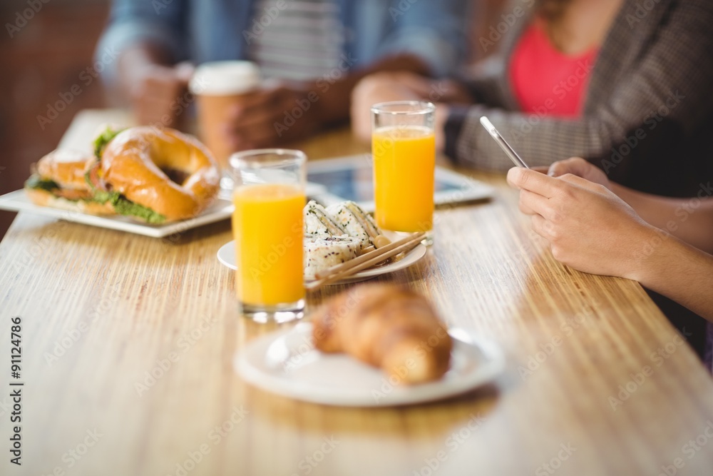 Cropped image of woman using phone during breakfast Cropped image of woman using phone during breakfast