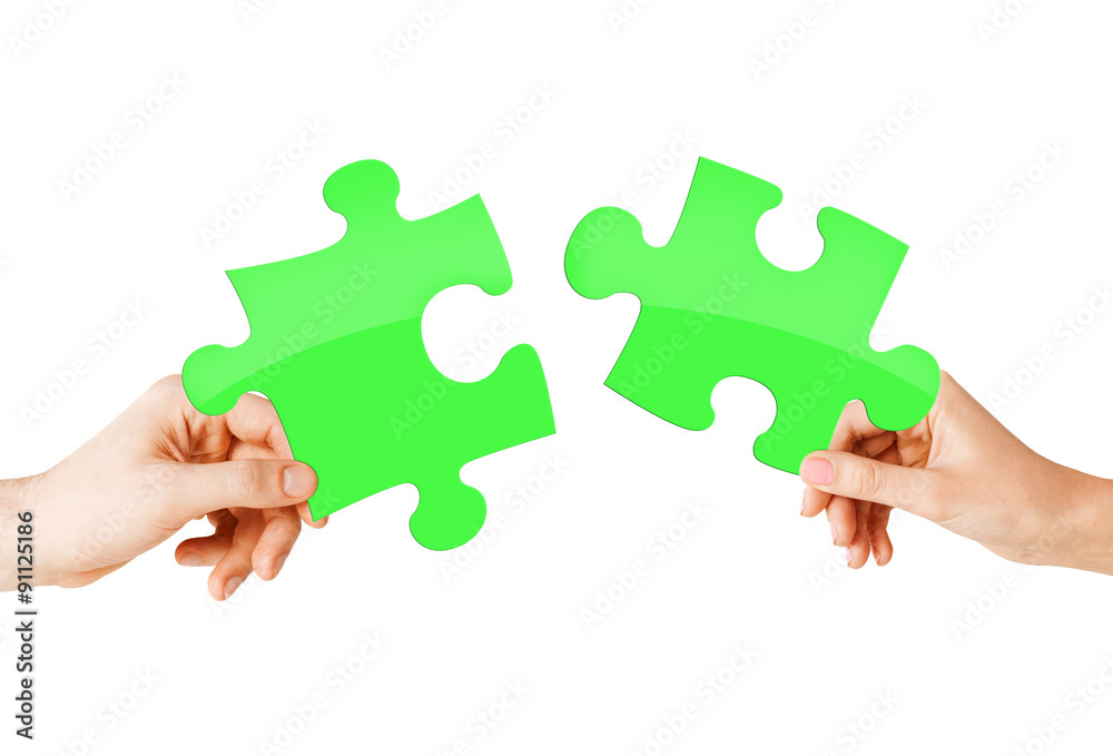 close up of couple hands with green puzzle pieces close up of couple hands with green puzzle pieces