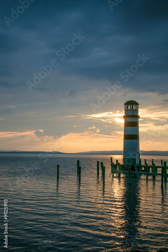 Seascape at sunset. Lighthouse on the coast.