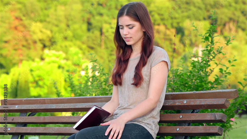 Attractive girl with a diary sitting on the bench Attractive girl with a diary sitting on the bench