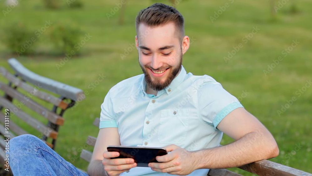 Boy sitting on a bench with a tablet Boy sitting on a bench with a tablet
