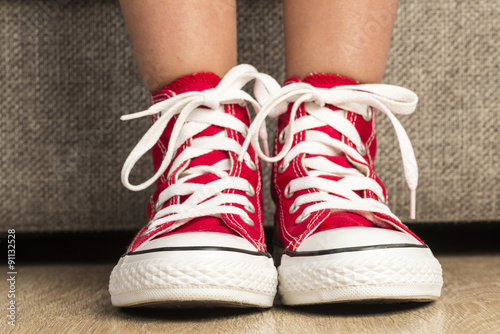 Girl wearing a pair of red sneakers