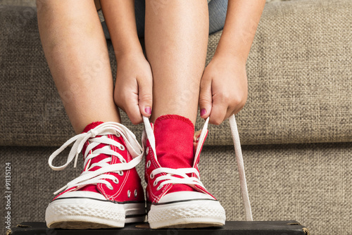 Girl wearing a pair of red sneakers