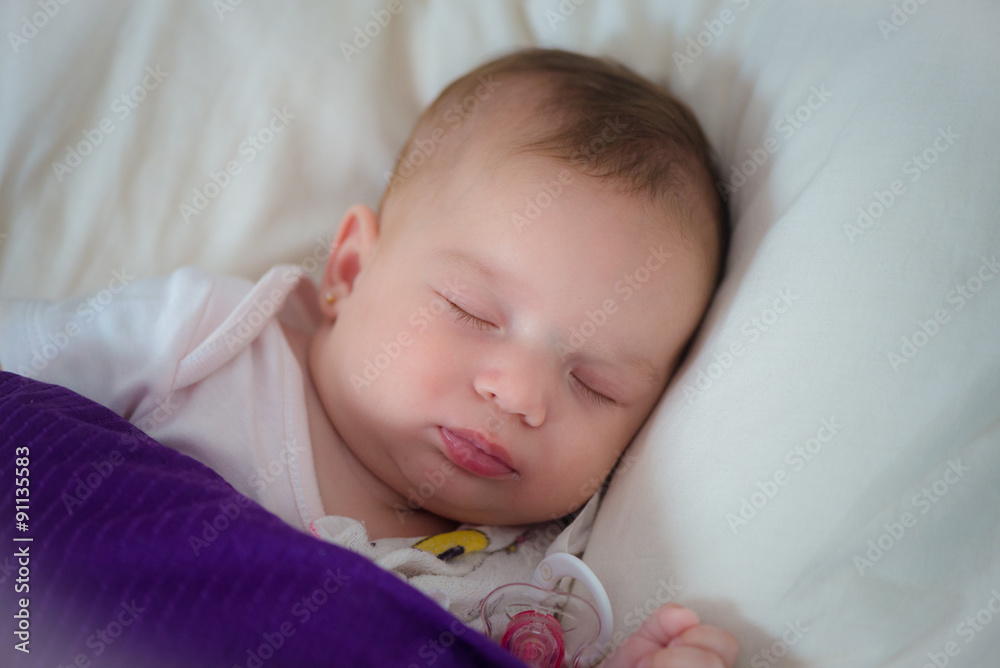 Peaceful baby lying on a bed while sleeping in a bright room Peaceful baby lying on a bed while sleeping in a bright room