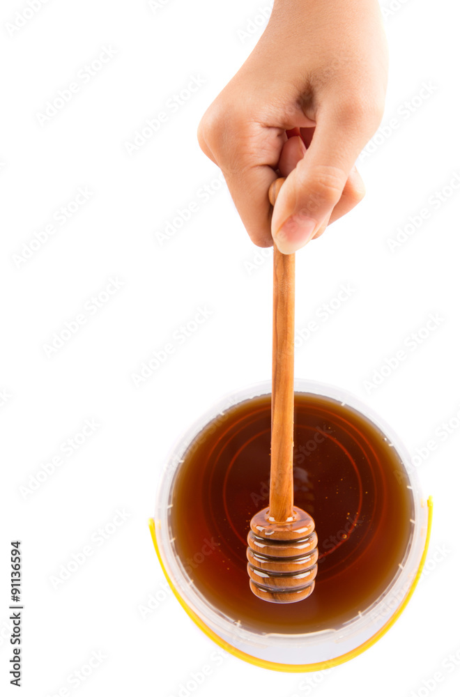 Holding honey dipper with natural honey over white background Holding honey dipper with natural honey over white background