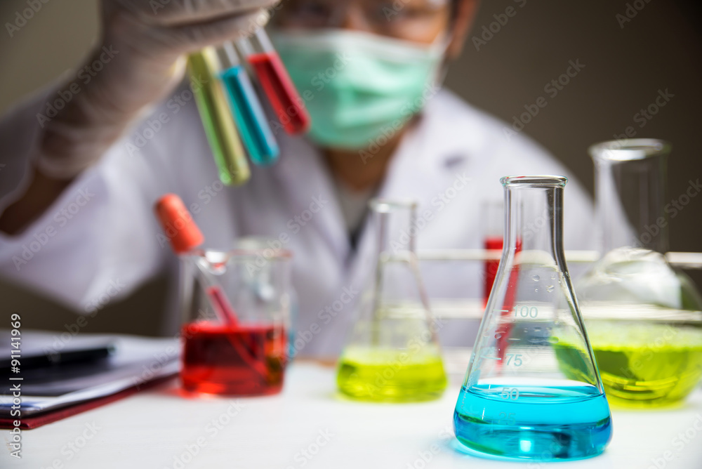 Laboratory glassware with out of focus scientist background Laboratory glassware with out of focus scientist background