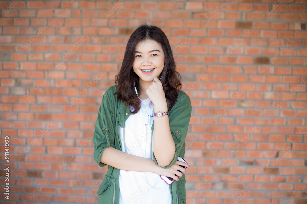 Happy asian woman with black Hair standing Against Old Brick Wal Happy asian woman with black Hair standing Against Old Brick Wal