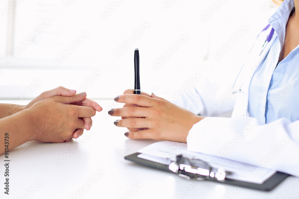 Doctor and patient are discussing something, just hands at the table Doctor and patient are discussing something, just hands at the table