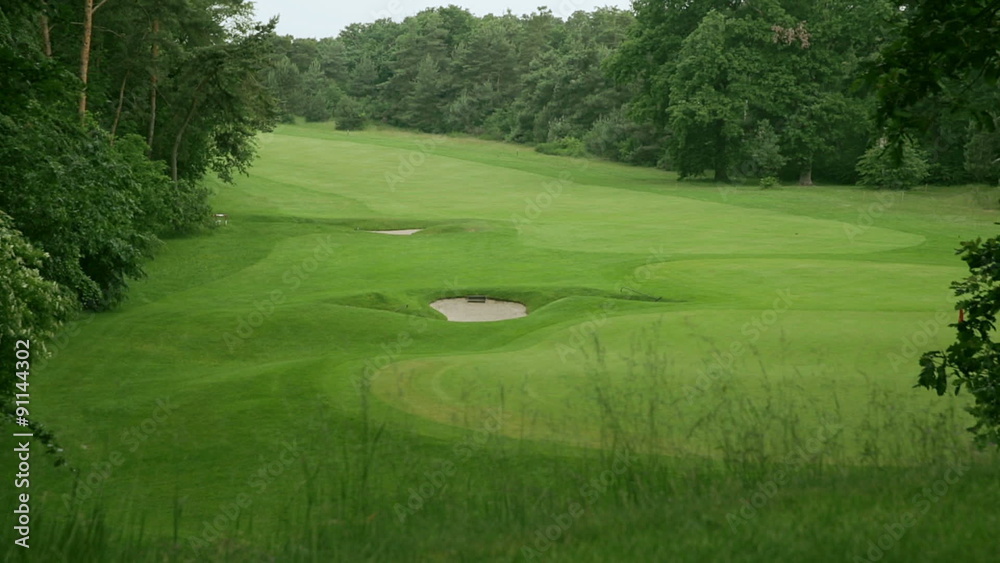 view above a golf course in germany. the grass is beautiful green and in the middle are two sand traps. view above a golf course in germany. the grass is beautiful green and in the middle are two sand traps.