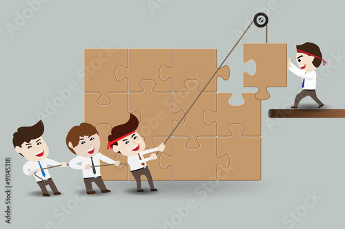 Teamwork, business men assembling pieces of a puzzle