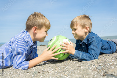 boy plays soccer on the beach photo