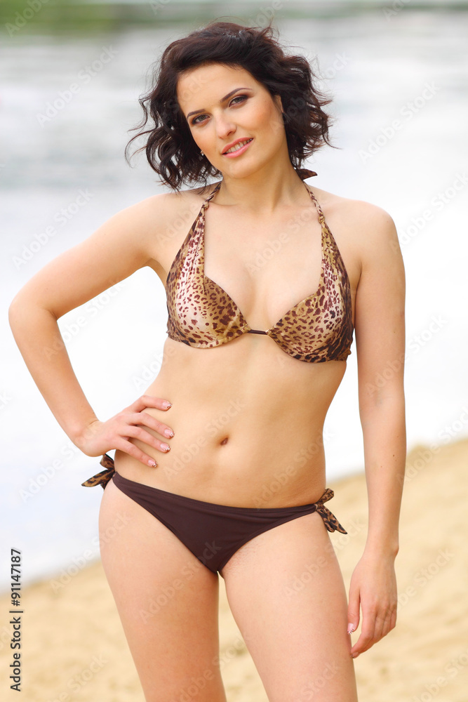 full girl posing on the beach in a bikini. plump woman sunbathing on the beach full girl posing on the beach in a bikini. plump woman sunbathing on the beach