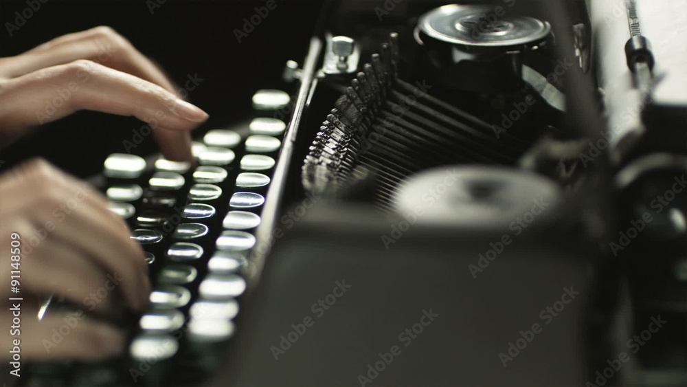 fingers typing on the keyboard of an old-fashioned typewriter