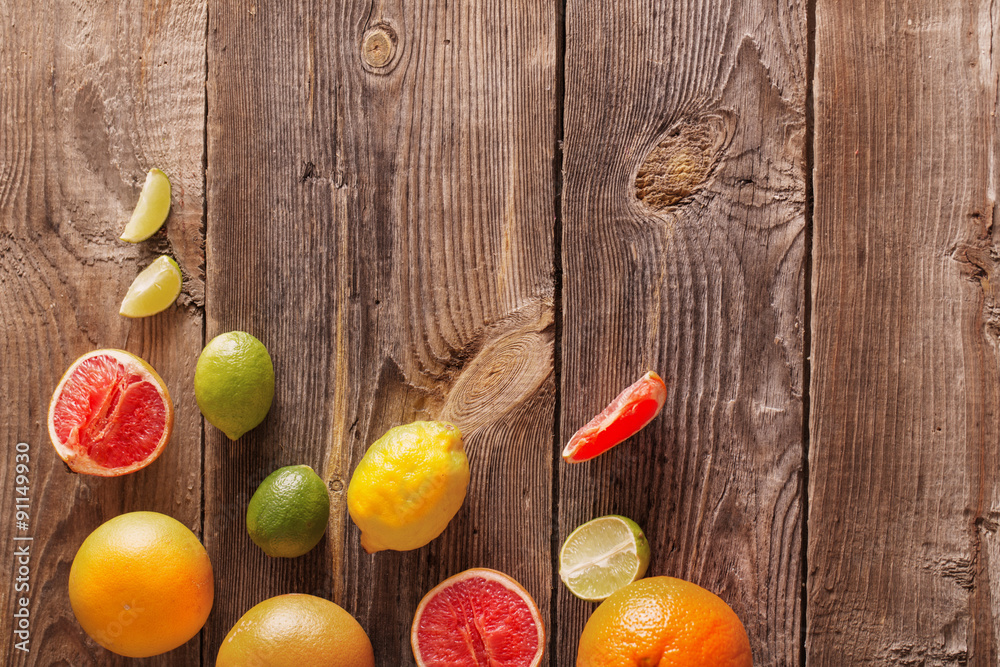 Set of sliced citrus fruits over wooden background