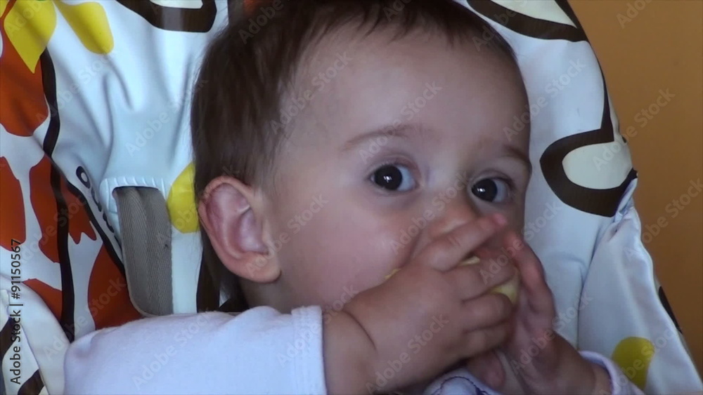 Baby eating a orange closeup