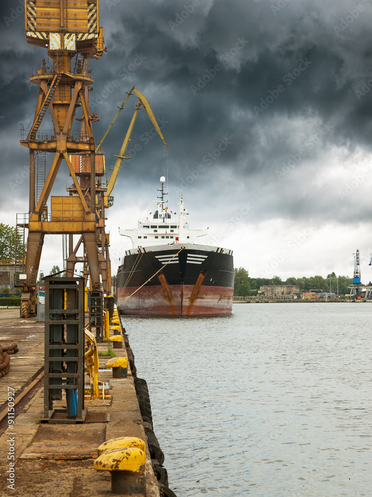 Cargo ship in port at cloudy day.