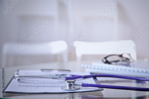 Purple stethoscope on the glass desk