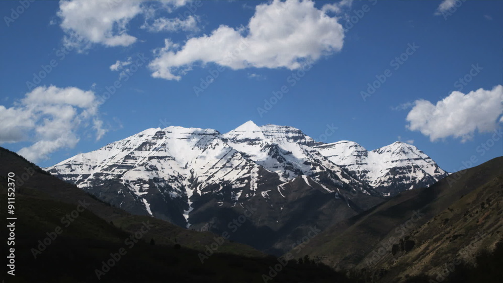 clouds passing over a snowcapped mountain range clouds passing over a snowcapped mountain range