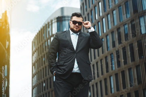 Portrait of successful business man while standing in city