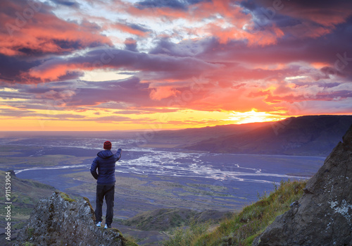 Man enjoying a colorfull sunset on Iceland. photo