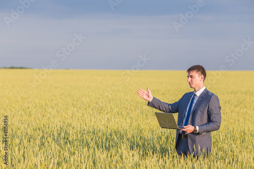 Businessman on a wheat field 