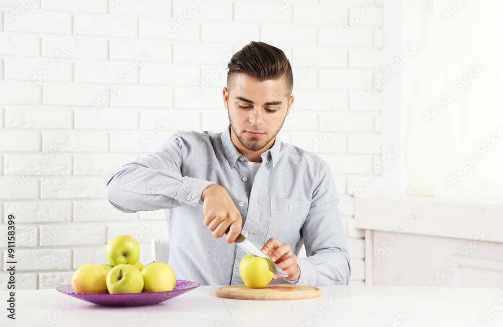 Young man cutting apples, preparing apple juice Young man cutting apples, preparing apple juice