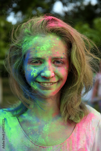 Young woman on Holi color festival in park