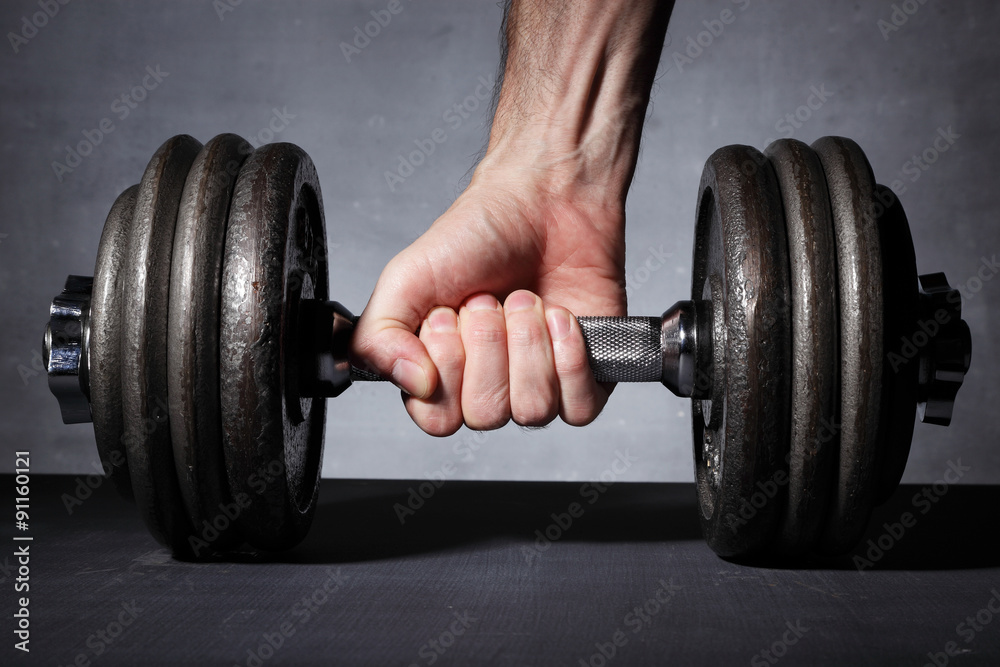 A man's hand grabbing a dumbbell A man's hand grabbing a dumbbell