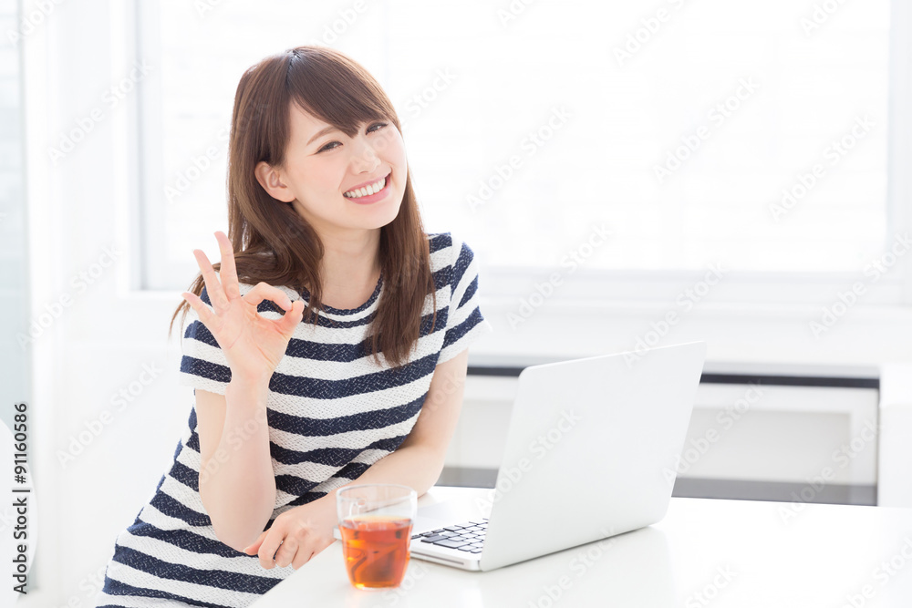 部屋でパソコンを使う女性