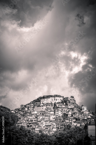 Artistic black and white town on a hill with cloudy sky