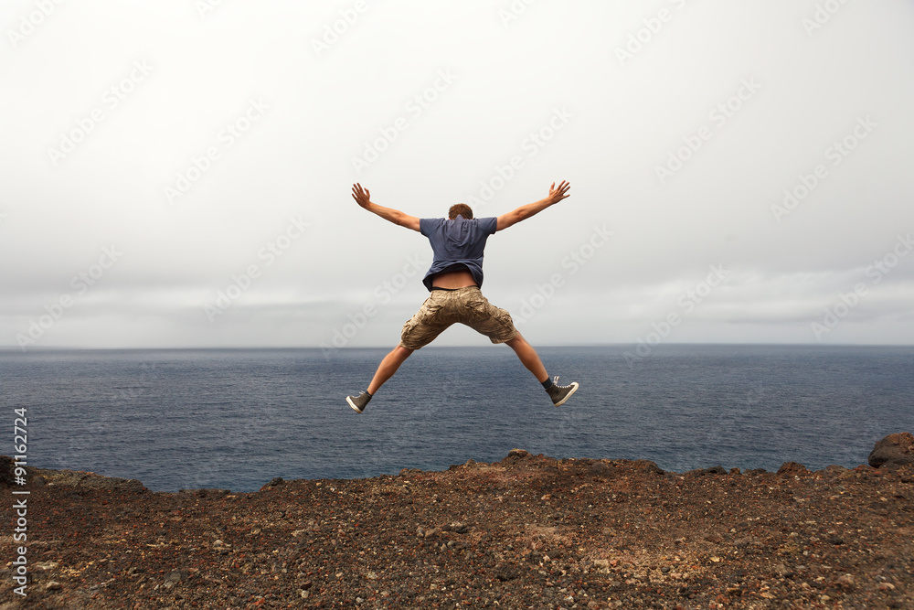 Freedom or adventure concept - jump of young man Freedom or adventure concept - jump of young man