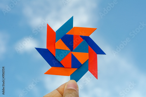 Fototapeta Naklejka Na Ścianę i Meble -  Hand holding colorful weathercock origami folding paper