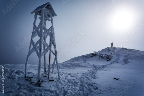 Lone man on the top of the mountain in winter