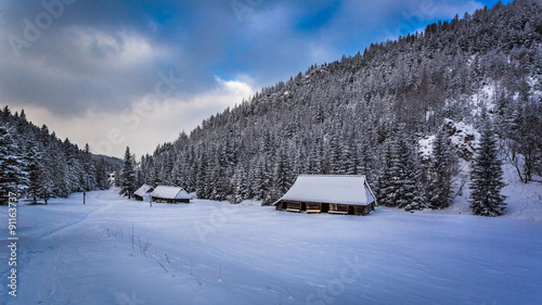 Old wooden cottages in winter mountains