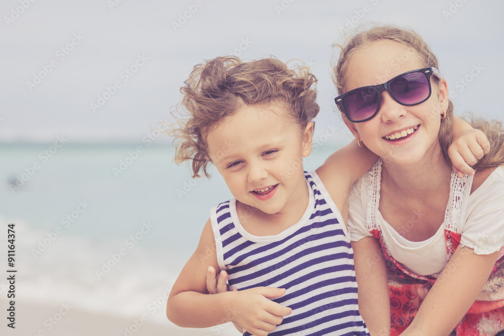 Sister and brother playing on the beach at the day time. Sister and brother playing on the beach at the day time.