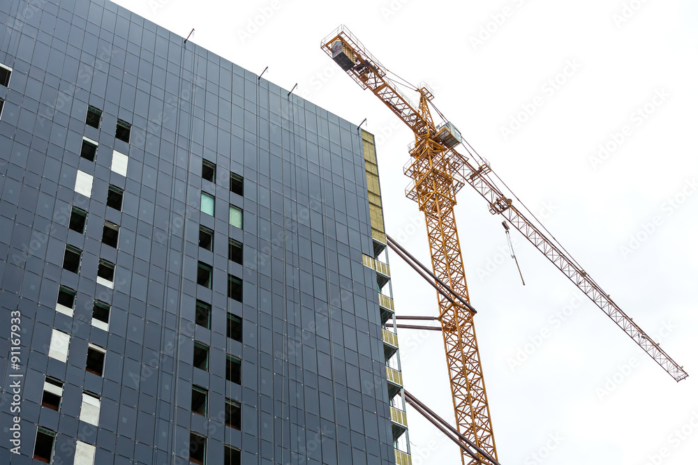 high-rise building under construction with crane