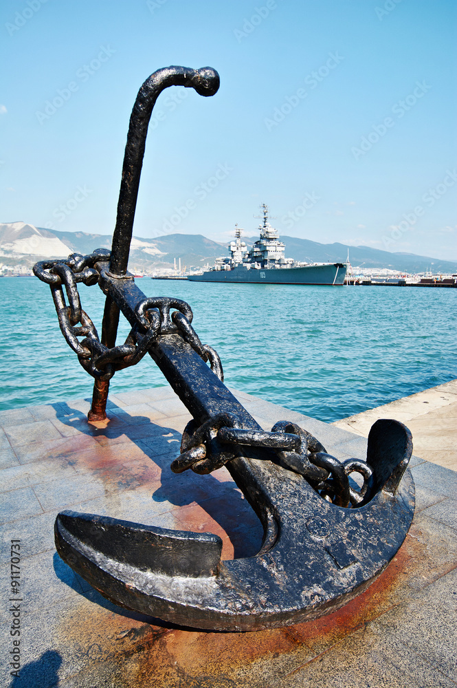 Fototapeta premium Anchor on embankment and cruiser in port