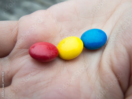 tricolor chocoloate bonbons in a hand photo