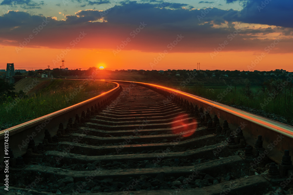 Fototapeta premium low red sun on sunset over railway