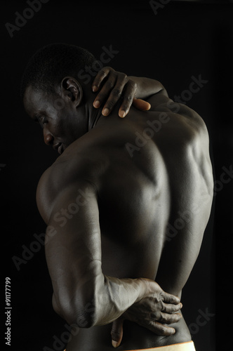 man with his hand on the back because you have pain, black background © curto