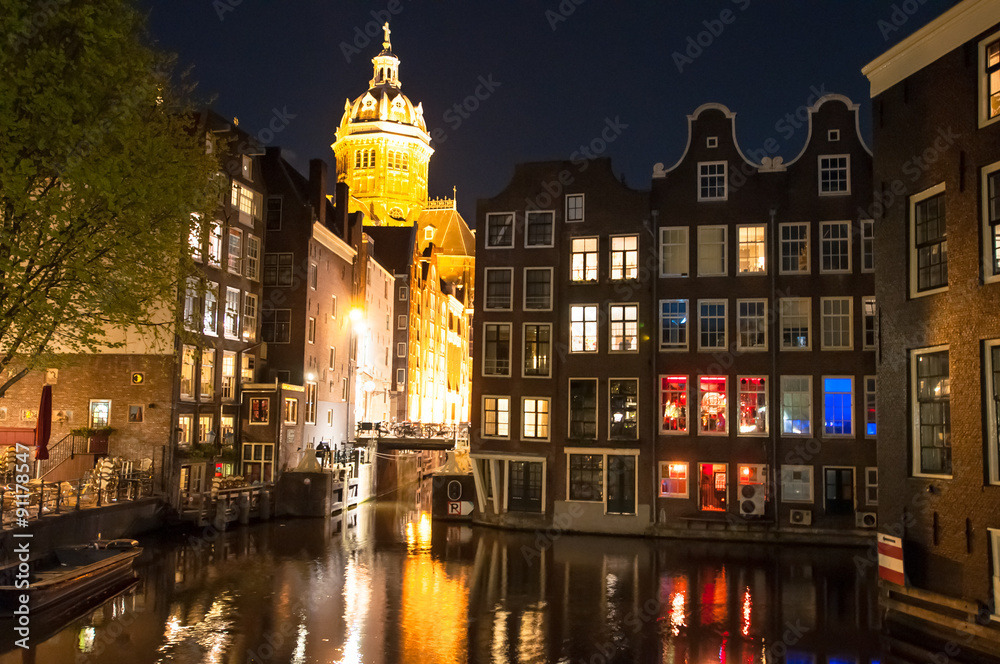 Fototapeta premium Red light district at night, the Church of St. Nicholas is visible in the distance, the Netherlands.