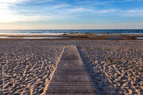 Wooden footpath to the sea at sunset.