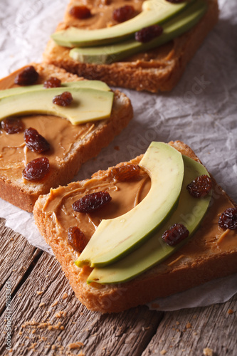 Healthy breakfast: sandwiches with avocado and peanut cream. vertical
