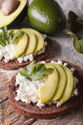 Dietary sandwiches with avocado, cottage cheese and arugula closeup. vertical
