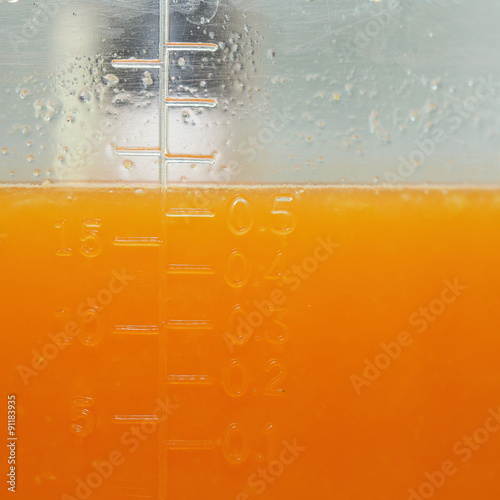 orange fruit squeezed with woman hand in juicer machine photo