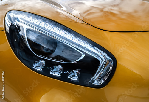 Closeup headlights of modern sport yellow car. Car exterior deta