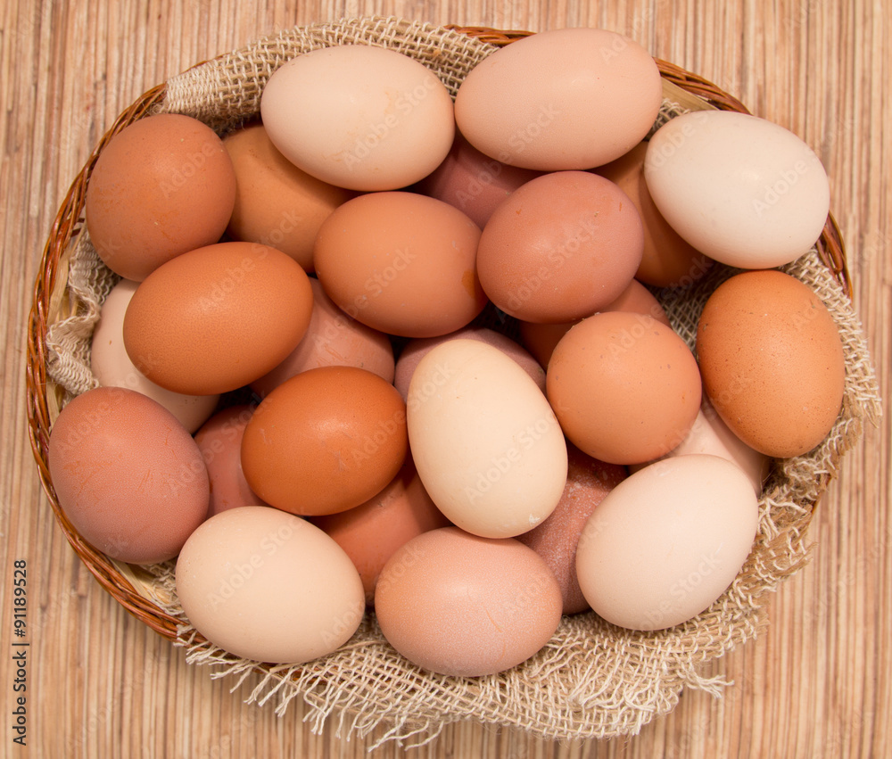 fresh eggs chicken in a basket on a wooden background fresh eggs chicken in a basket on a wooden background